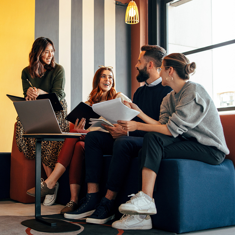 group of coworkers sitting on couch and having meeting